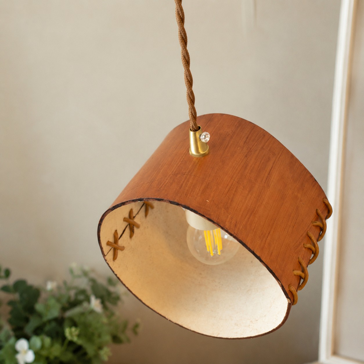 Leather pendant shade with visible bulb and stitched edge