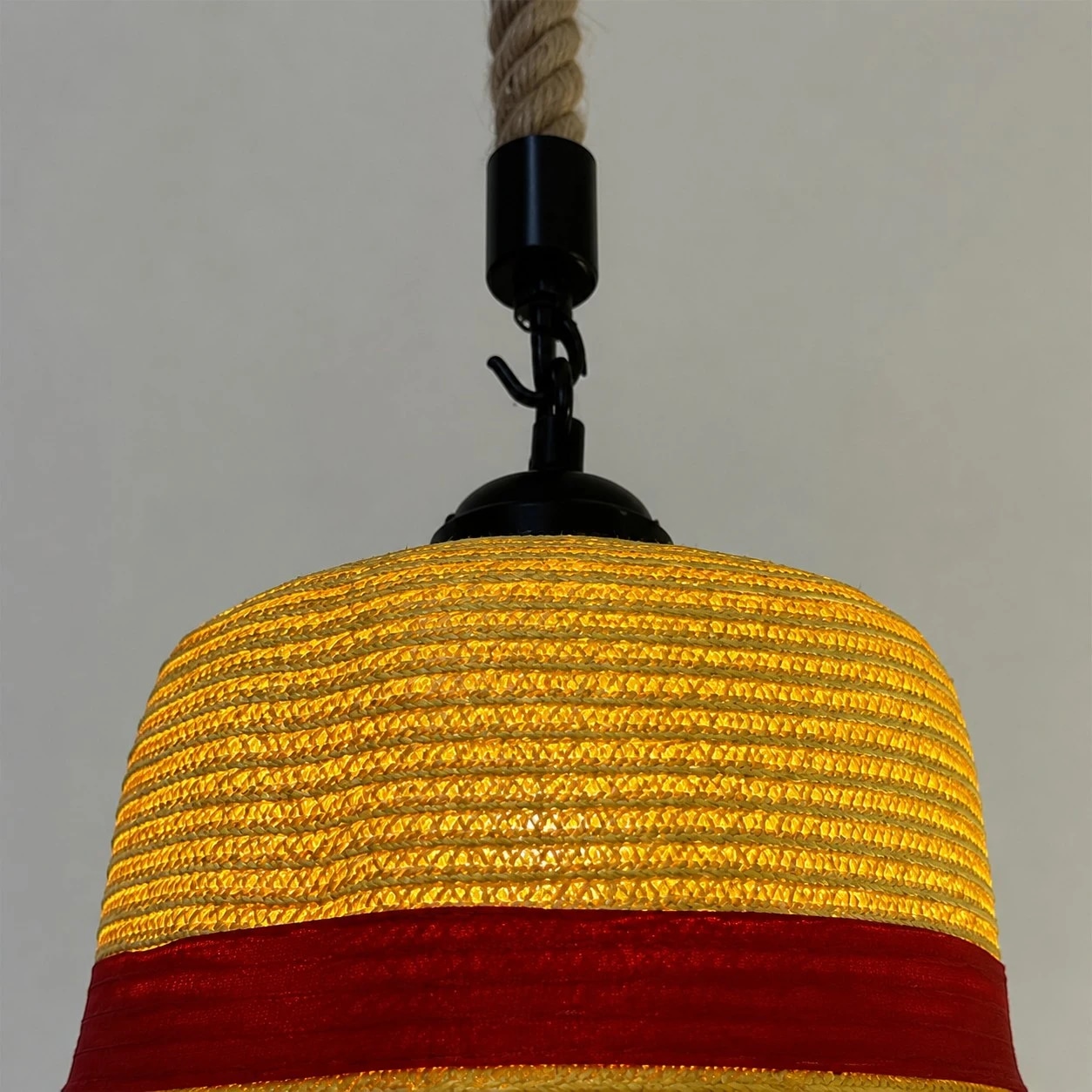 Layered straw texture, wide brim and a clean red accent band.