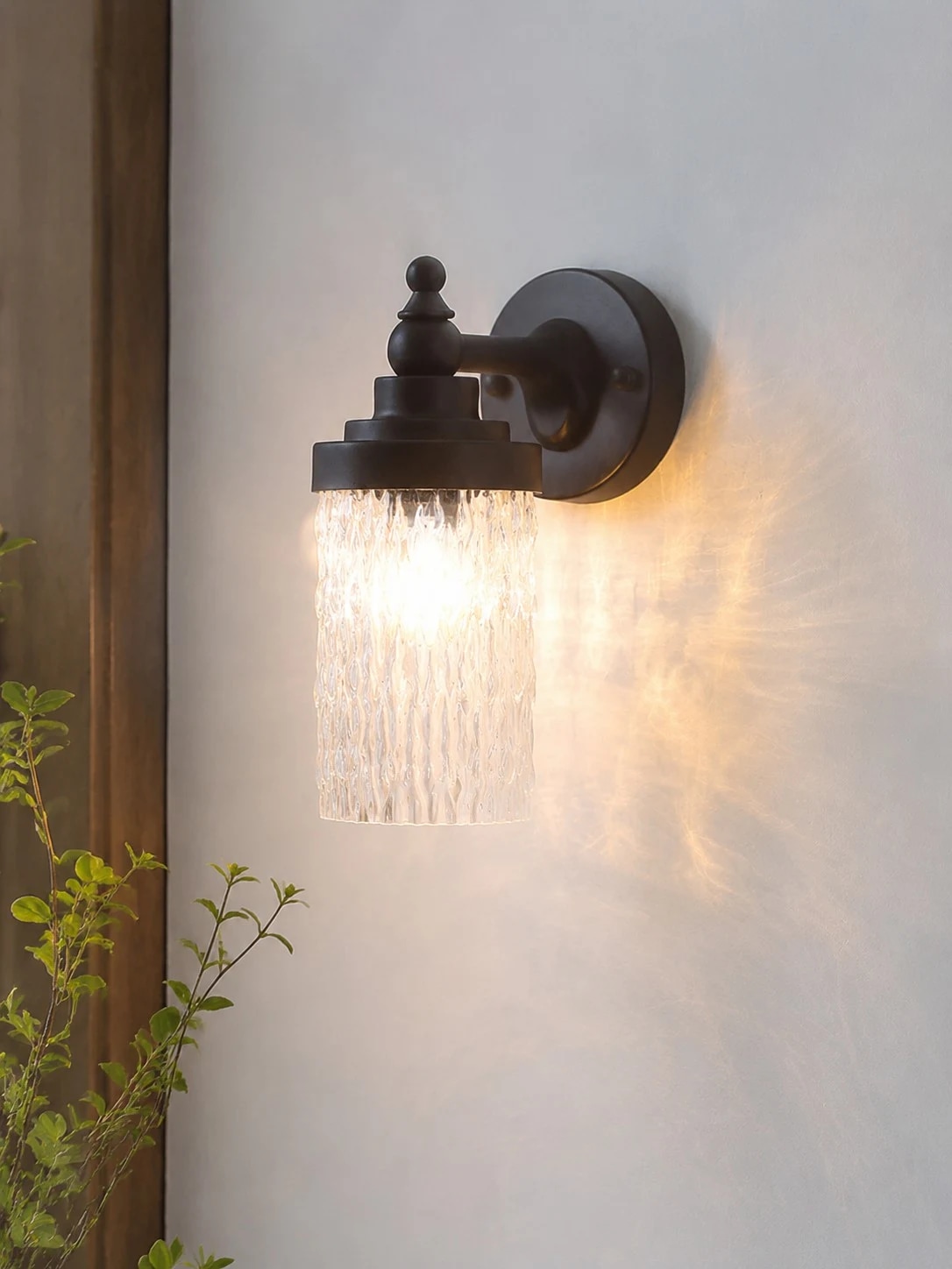 Black wall sconce mounted near a doorway
