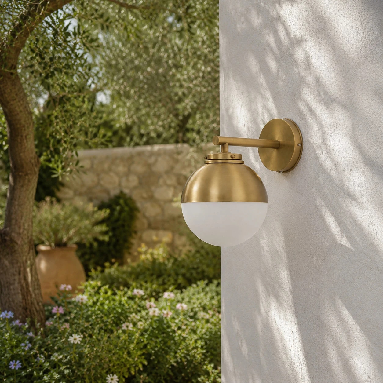 Vintage brass wall lamp installed on a white exterior garden wall