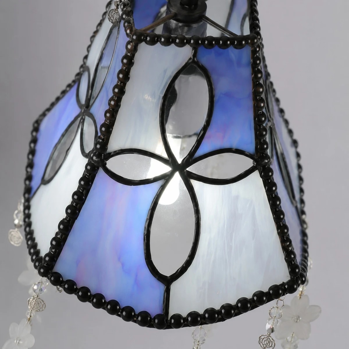 Side view of shell shade panels and black beaded frame