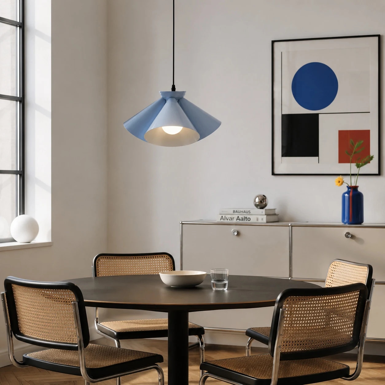 Blue Bauhaus pendant lamp installed above a dining table