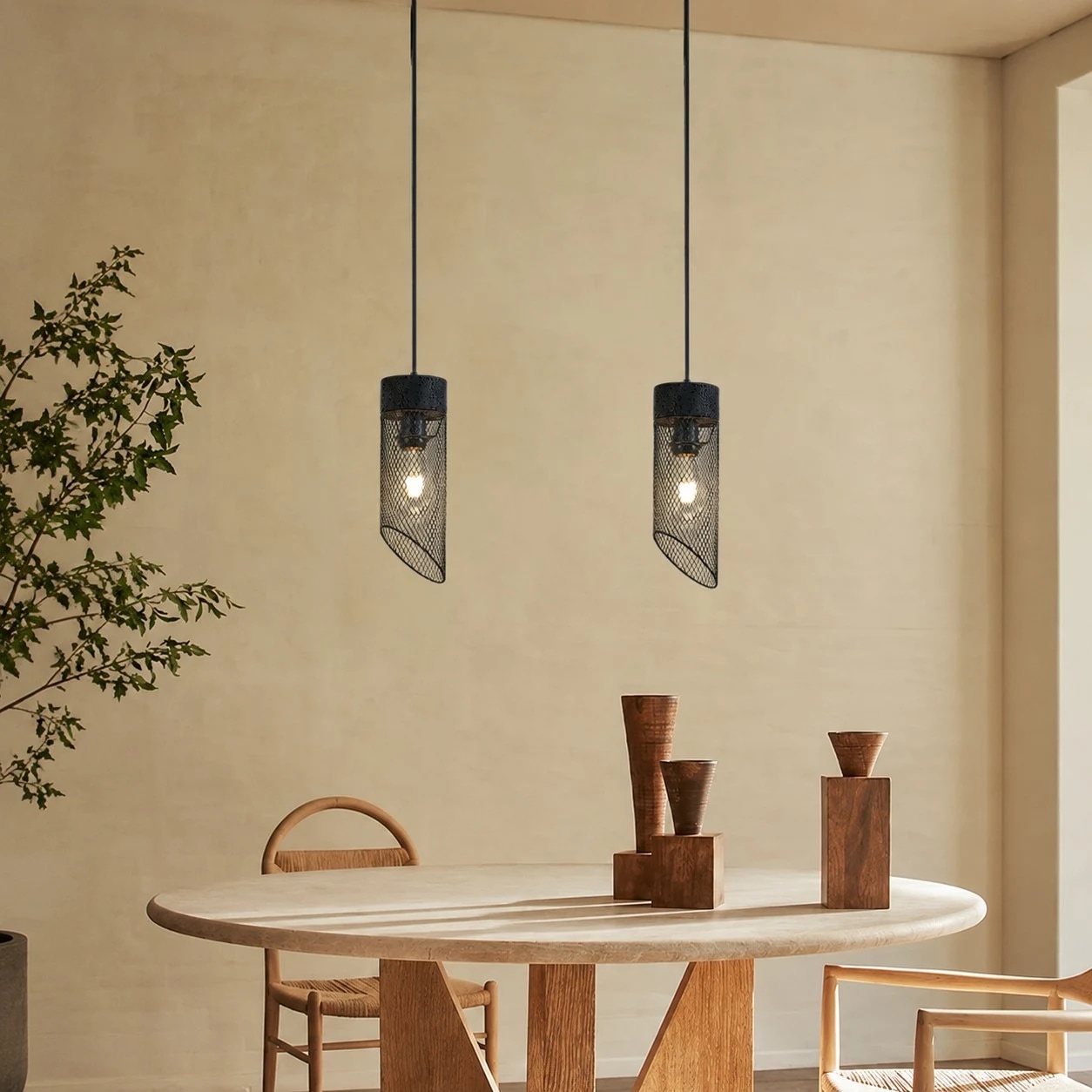Black mesh stone pendant light installed above a round dining table
