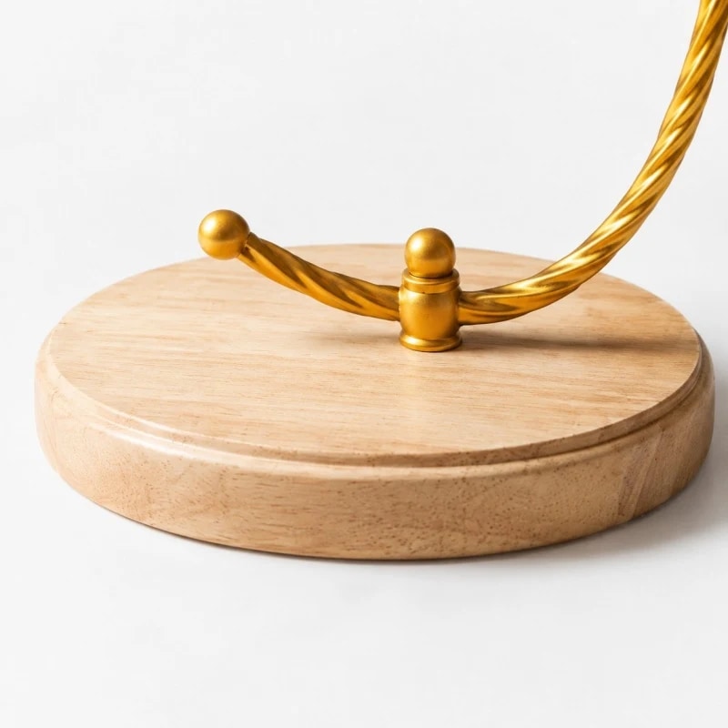 Close view of the round wood base and gold lamp stem