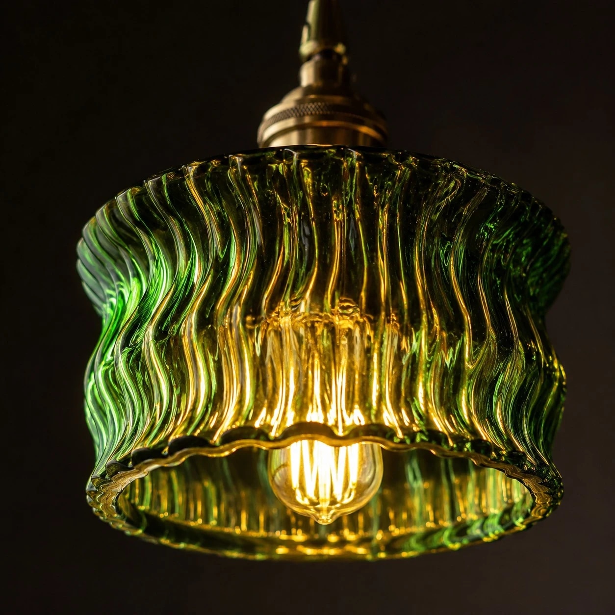 Warm light glowing through a green ripple glass pendant shade
