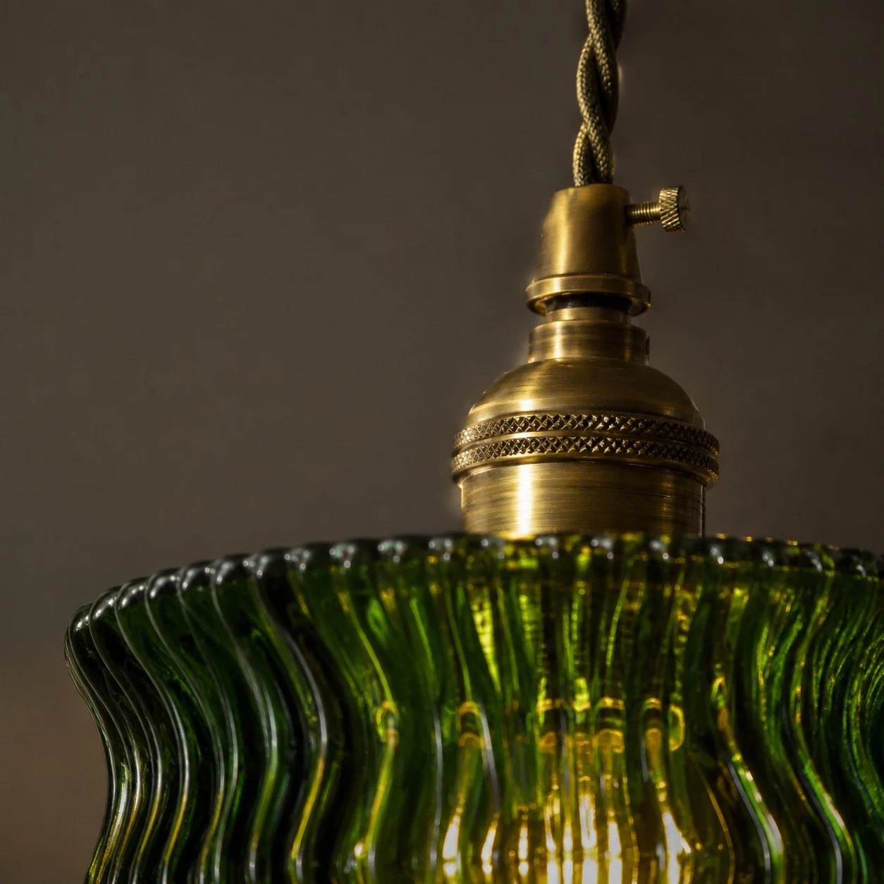 Brass-tone lamp head detail above the green glass shade