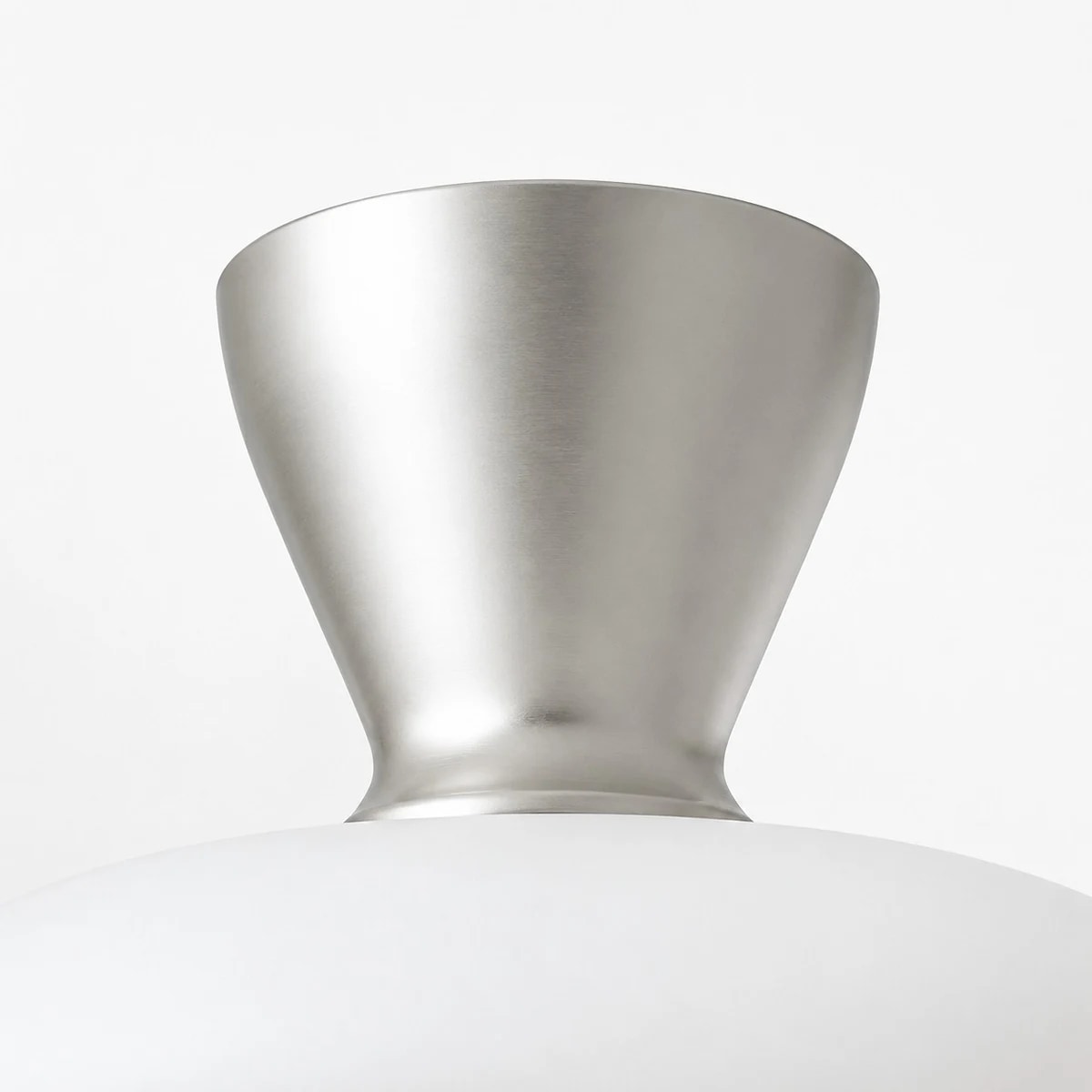 Detalle de la cubierta de metal plateado y la pantalla de cristal blanco en la lámpara de techo Konos.