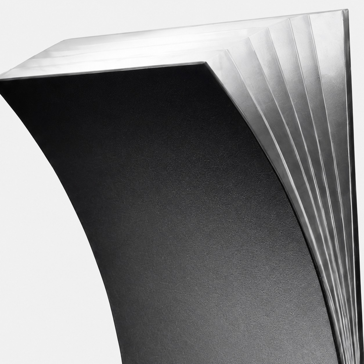 Close detail of black curved wall sconce ribbed translucent edge