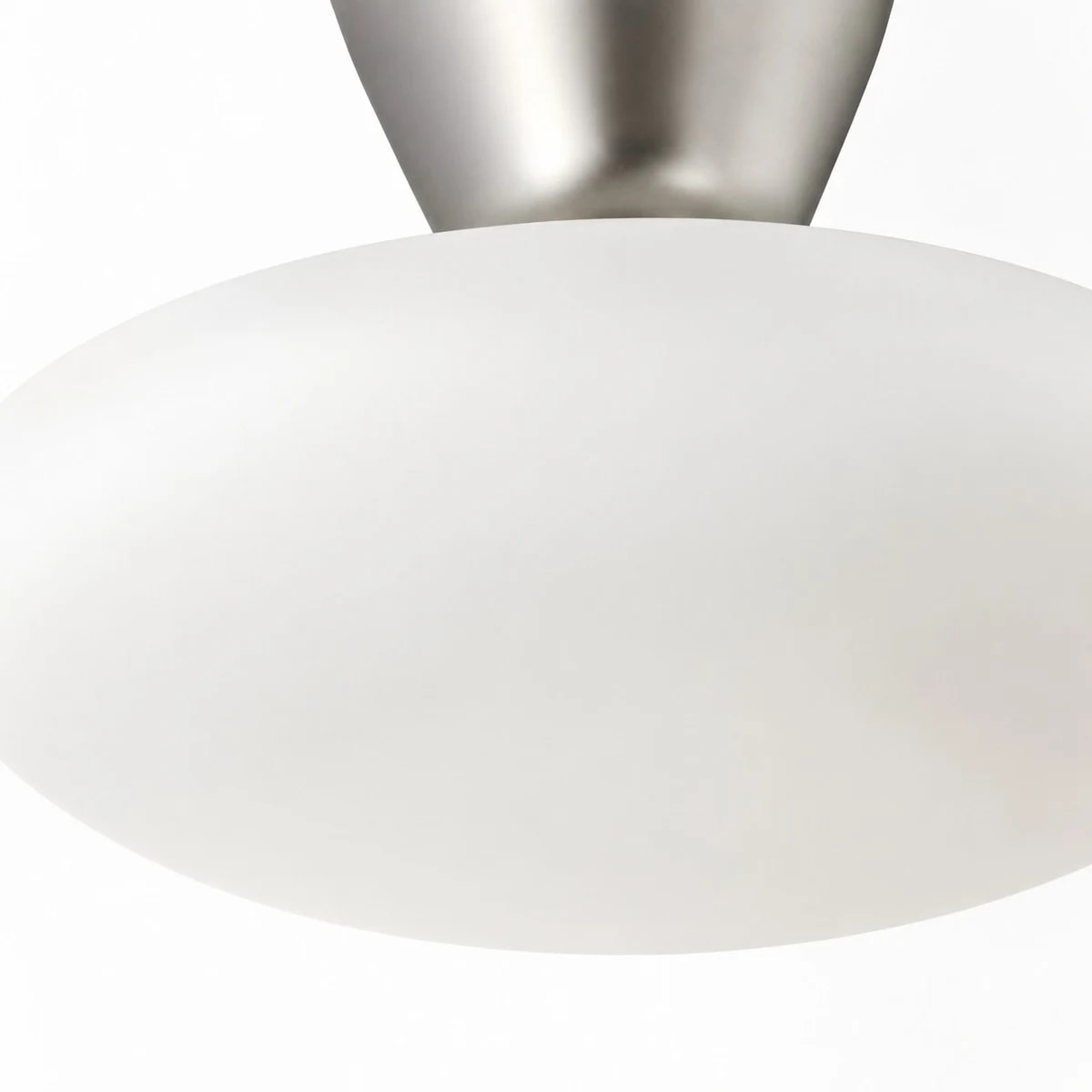 Primer plano de un difusor de cristal blanco en una lámpara de techo empotrada.