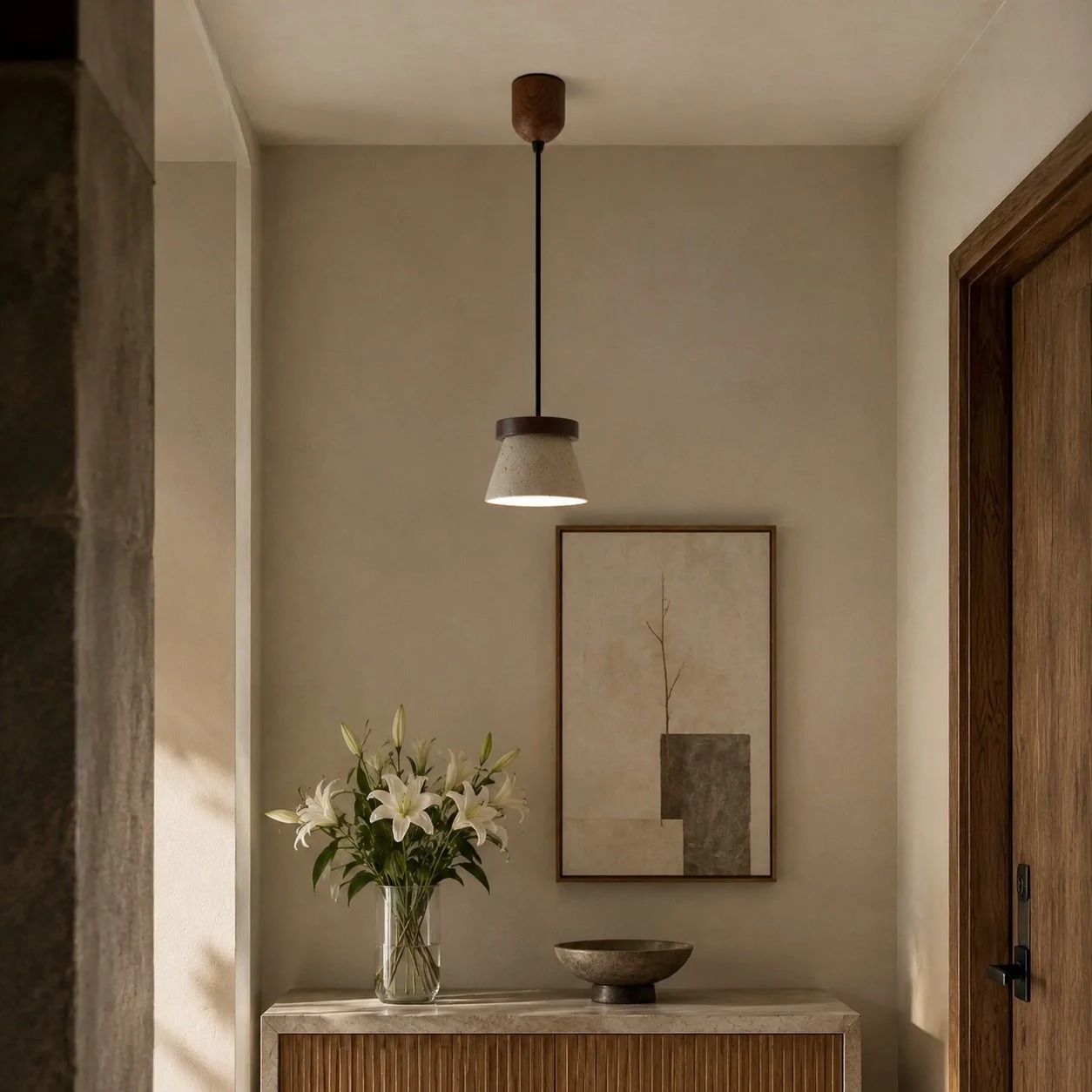 Pendant light above an entry console with wall art