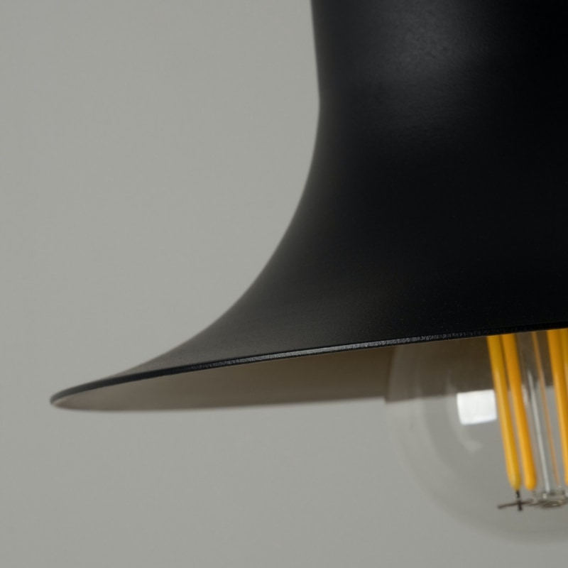 Close view of the textured pendant shade rim and warm bulb