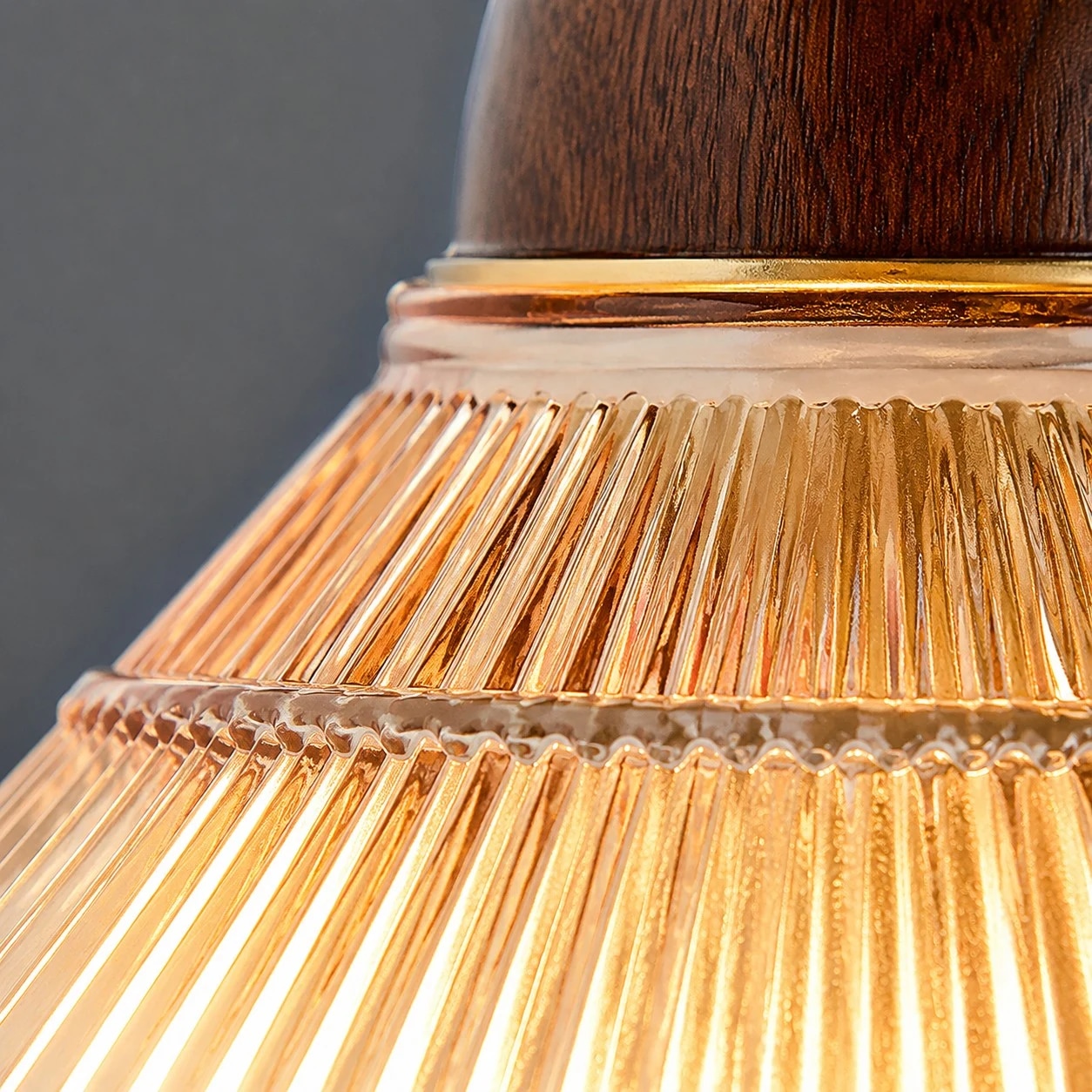 Ribbed shade, warm metal, and wood-tone contrast