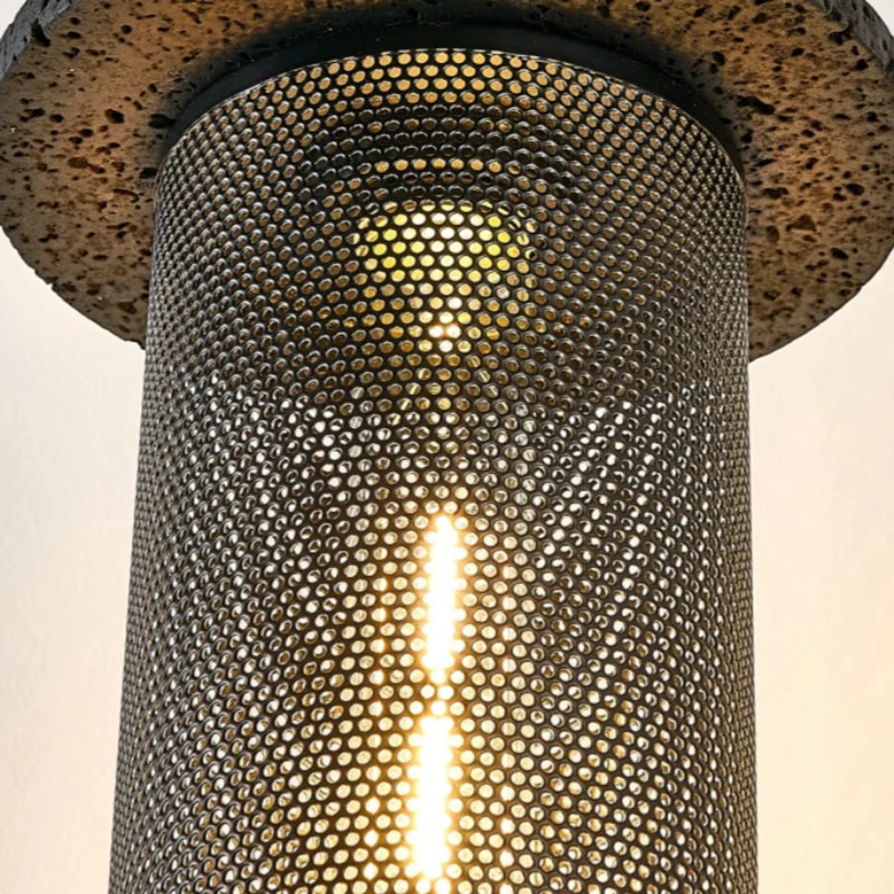 Close detail of the lit perforated woven pendant shade