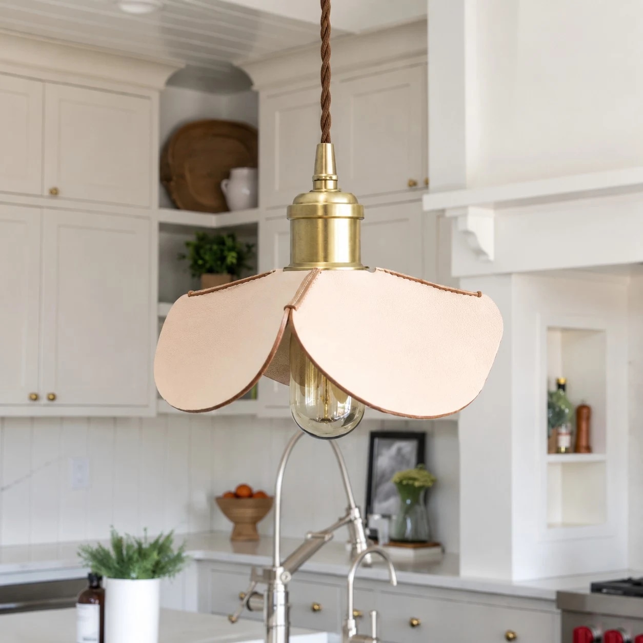 Hand-stitched leather petal pendant light styled in a bright kitchen