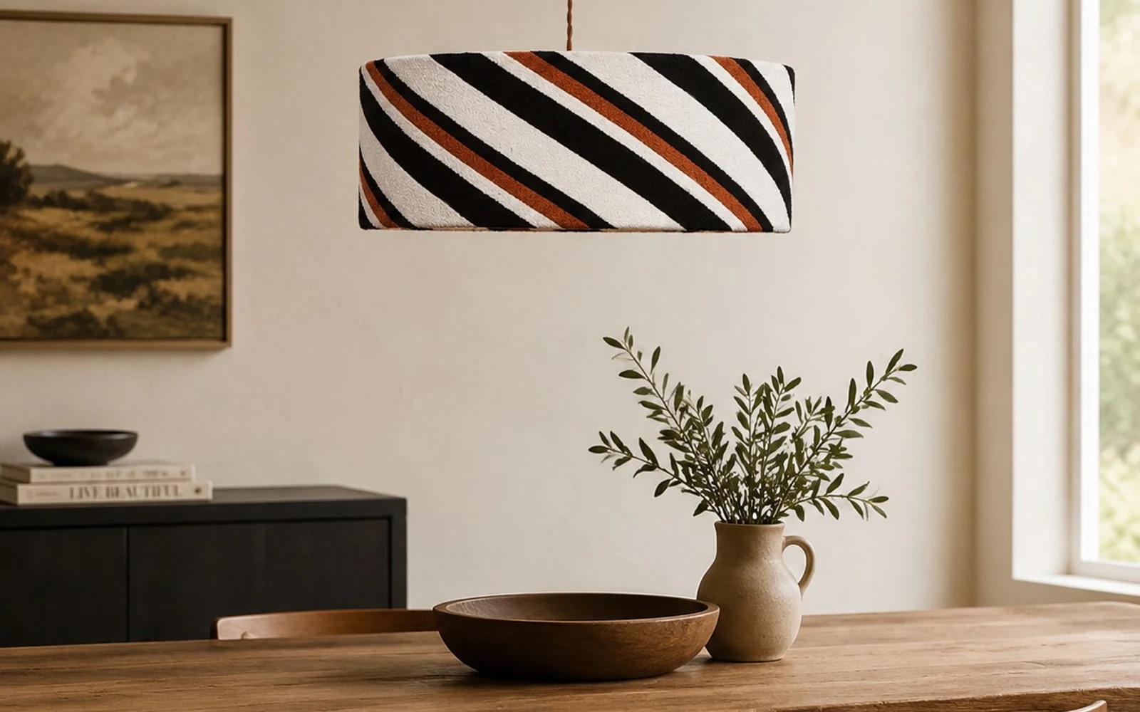 Striped fabric pendant light above a wood dining table