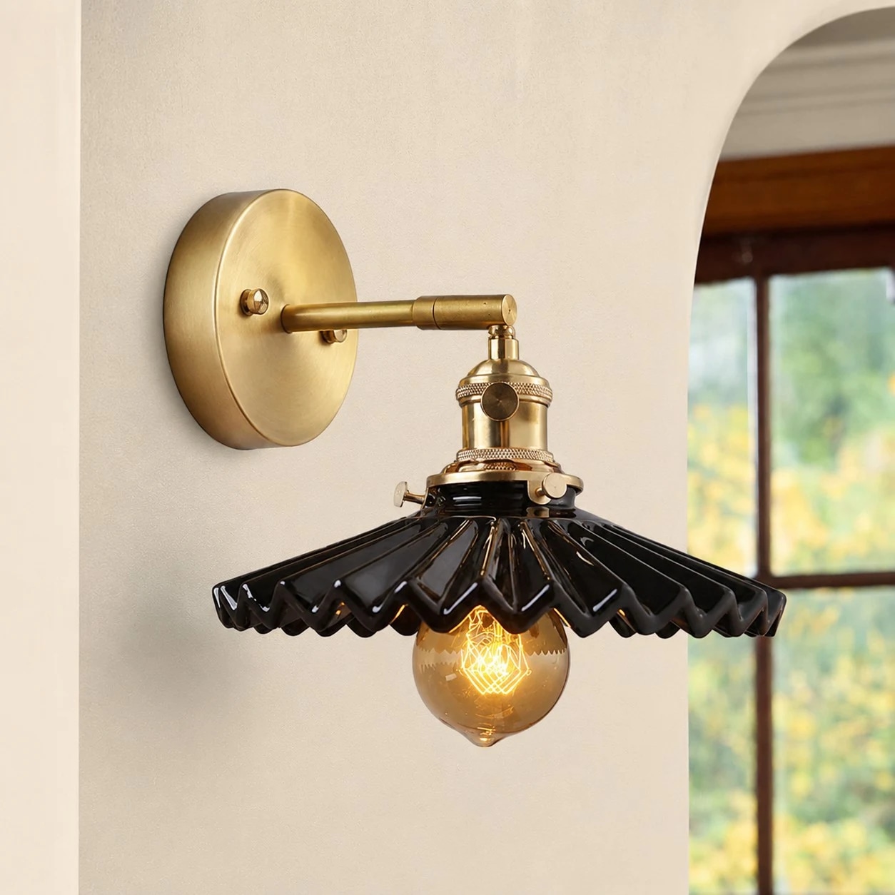 Black ceramic wall sconce near an arched window