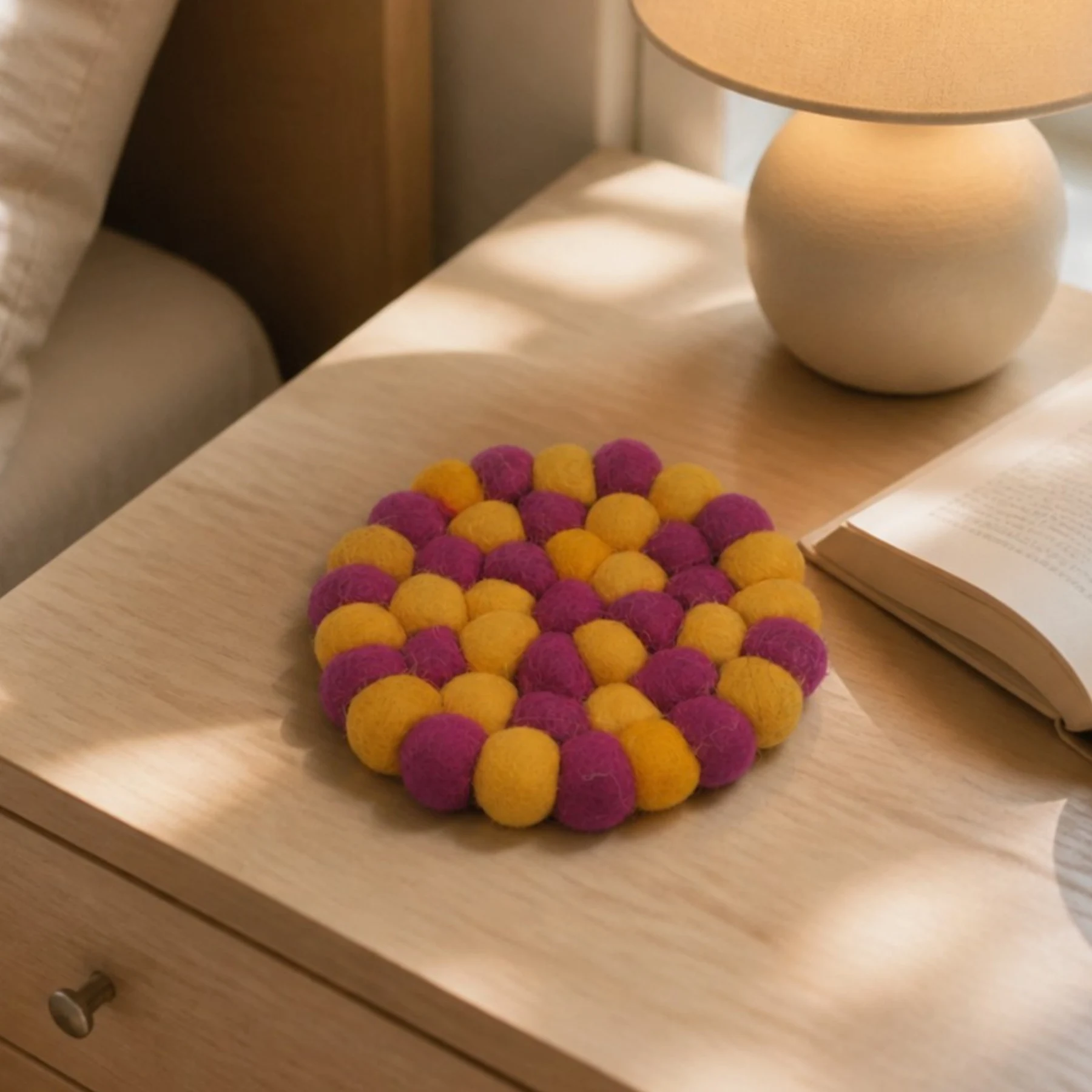 Posavasos de fieltro de colores sobre una mesita de noche.