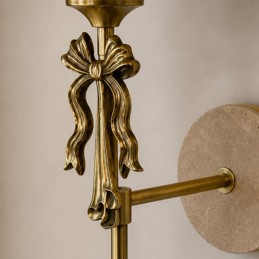 Nahaufnahme des skulpturalen Metallbogens und der Travertin-Wandplatte