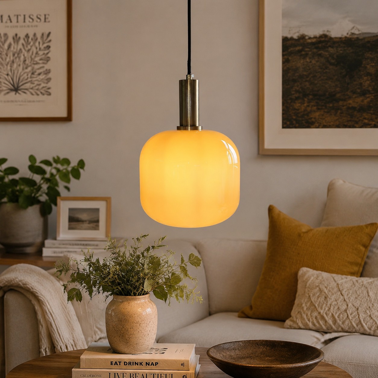 Luminária pendente de vidro amarelo em uma sala de estar decorada.