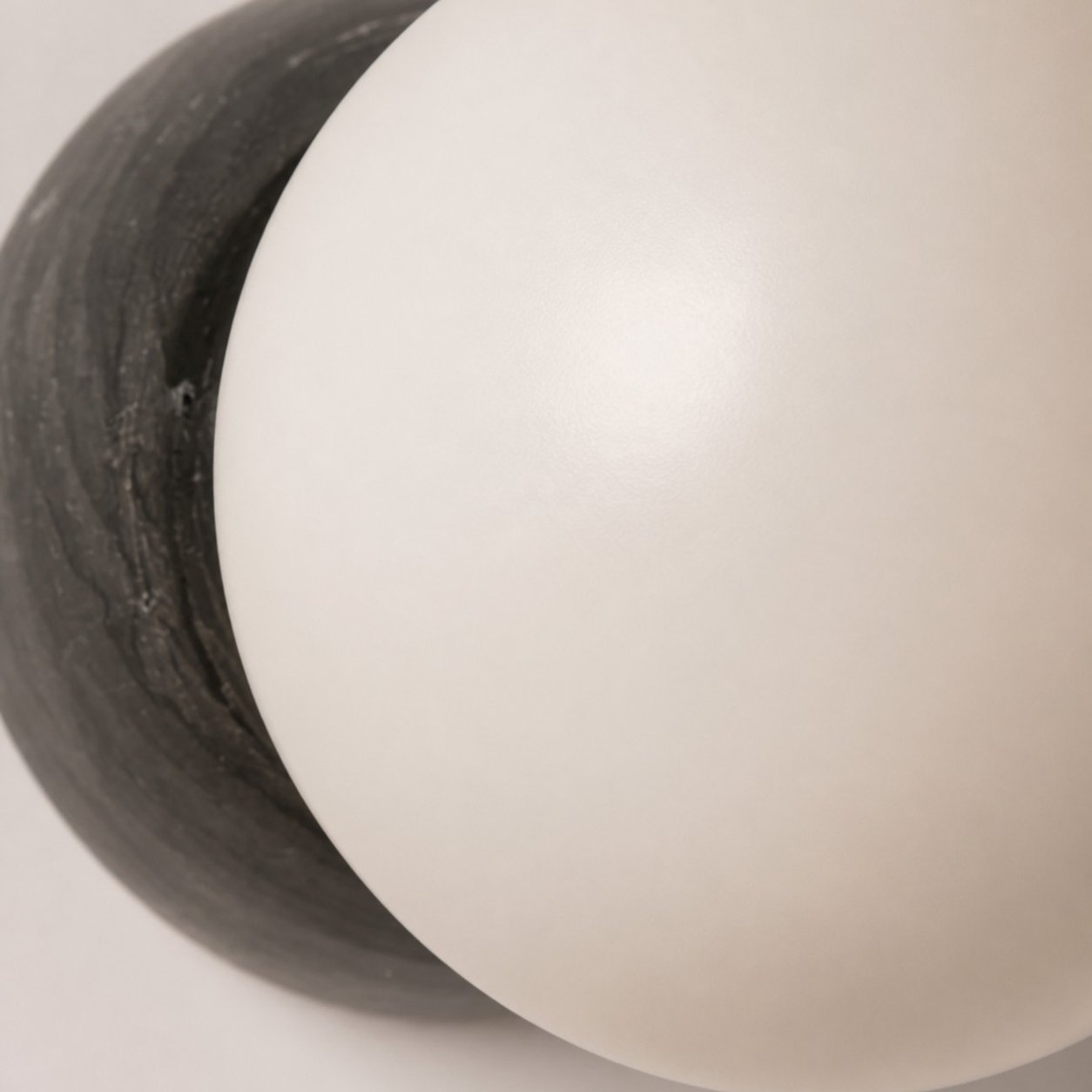 Close-up van de opalen matglazen bol en de zwartmarmeren achterplaat
