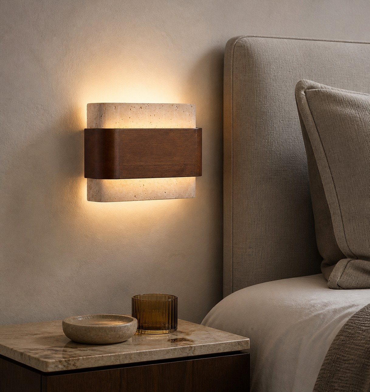 Wandlamp van travertijnhout naast het hoofdeinde van een slaapkamer.