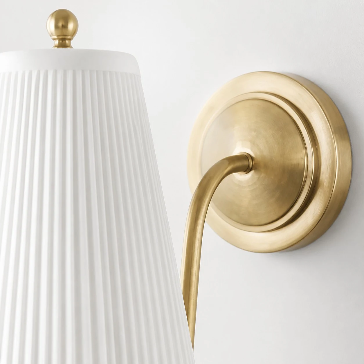 Detailopname van de messing achterplaat en de gebogen arm.