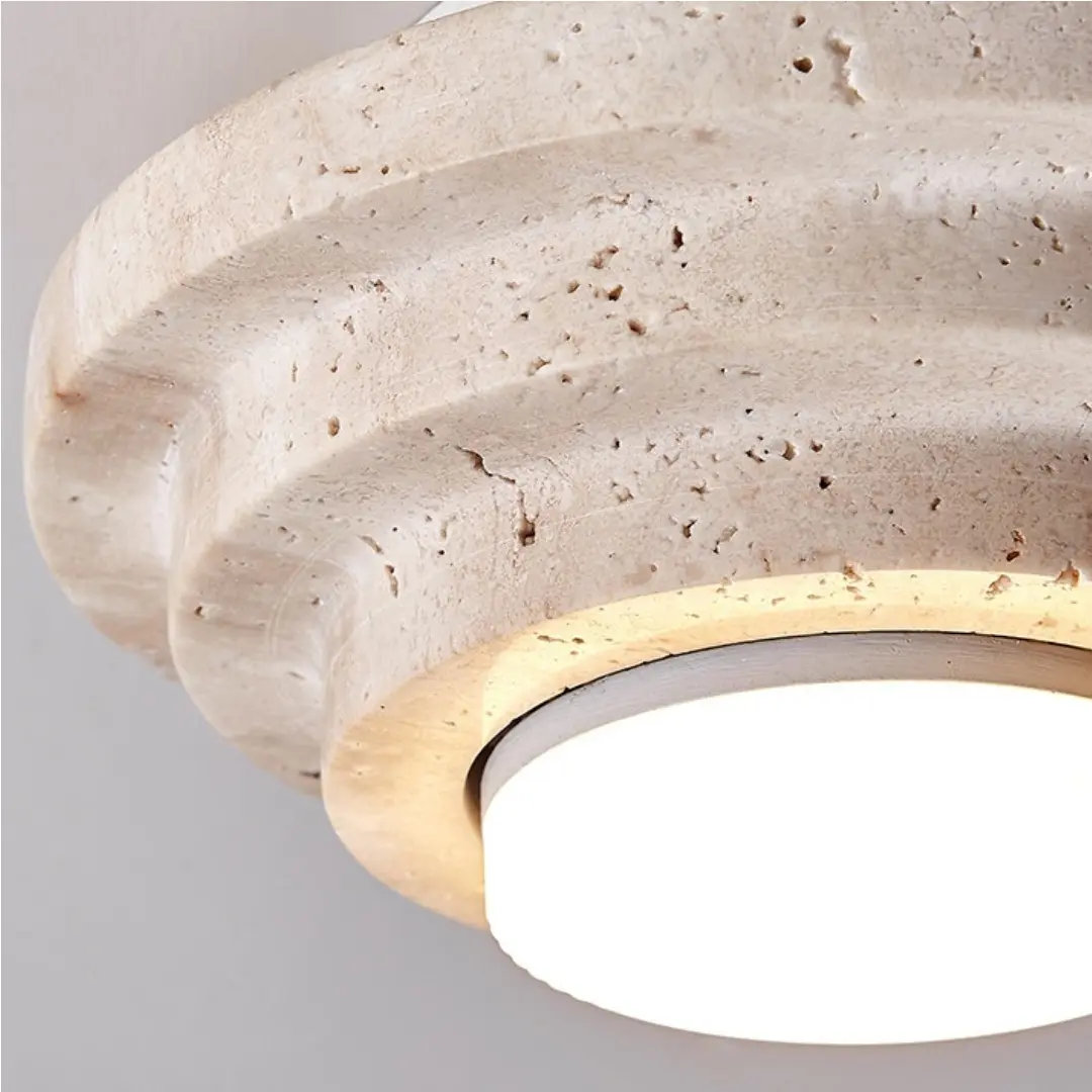 Detailopname van de travertinrand en de verlichte diffuser.