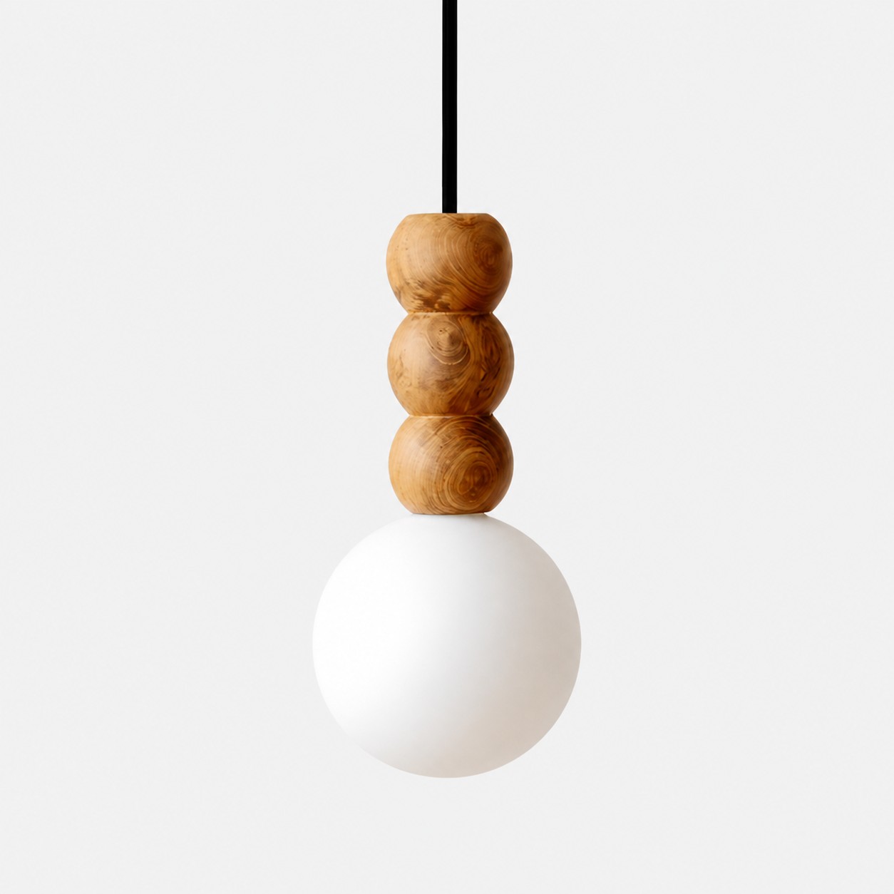 Luminária pendente escultural de madeira com três contas e globo de vidro fosco sobre fundo branco.
