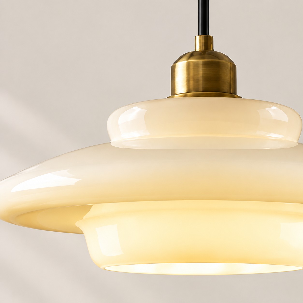 Verlichte, gelaagde hanglamp met kap van melkwit glas.