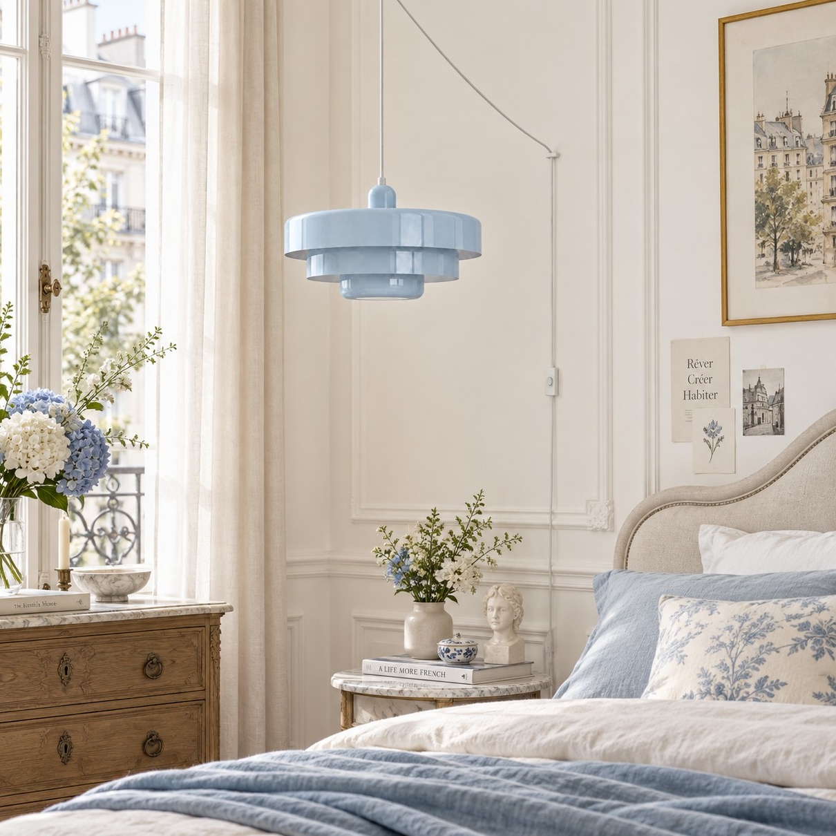 Light blue pendant light beside a blue and white bed