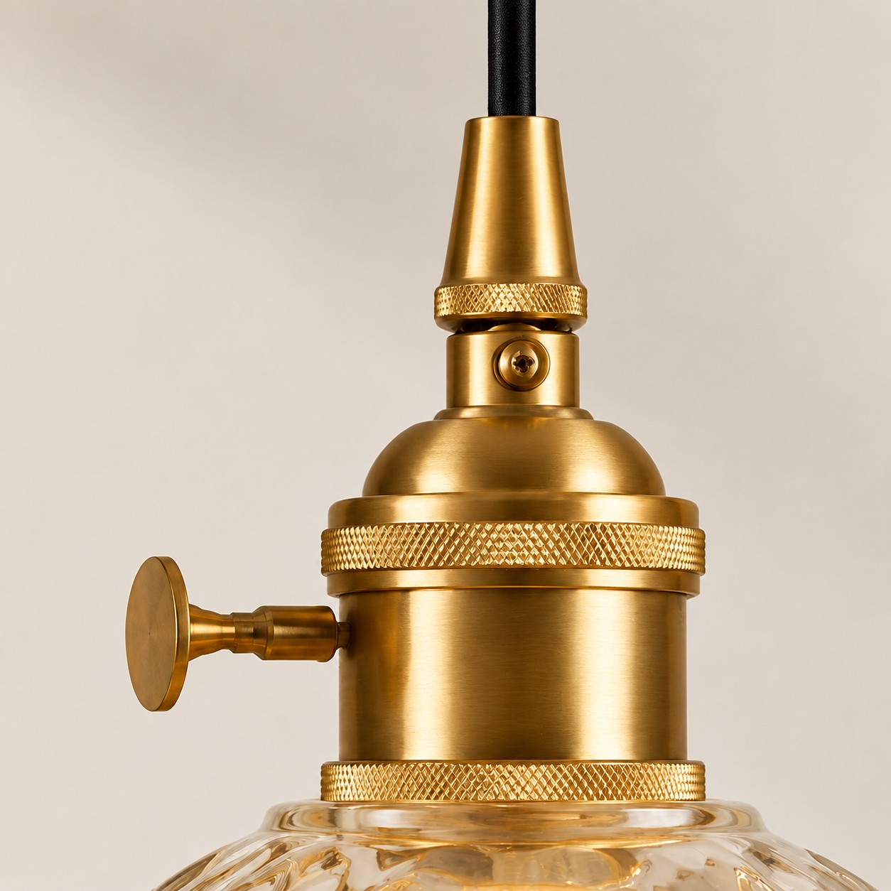 Goudkleurige metalen lamphouder met getextureerde ringen en een sleuteldetail aan de zijkant