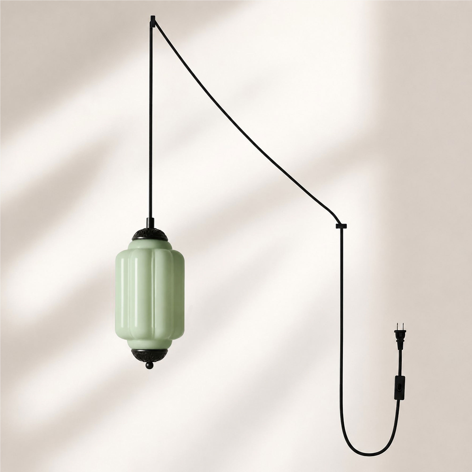 Lámpara colgante con acabado negro y pantalla de cristal verde.