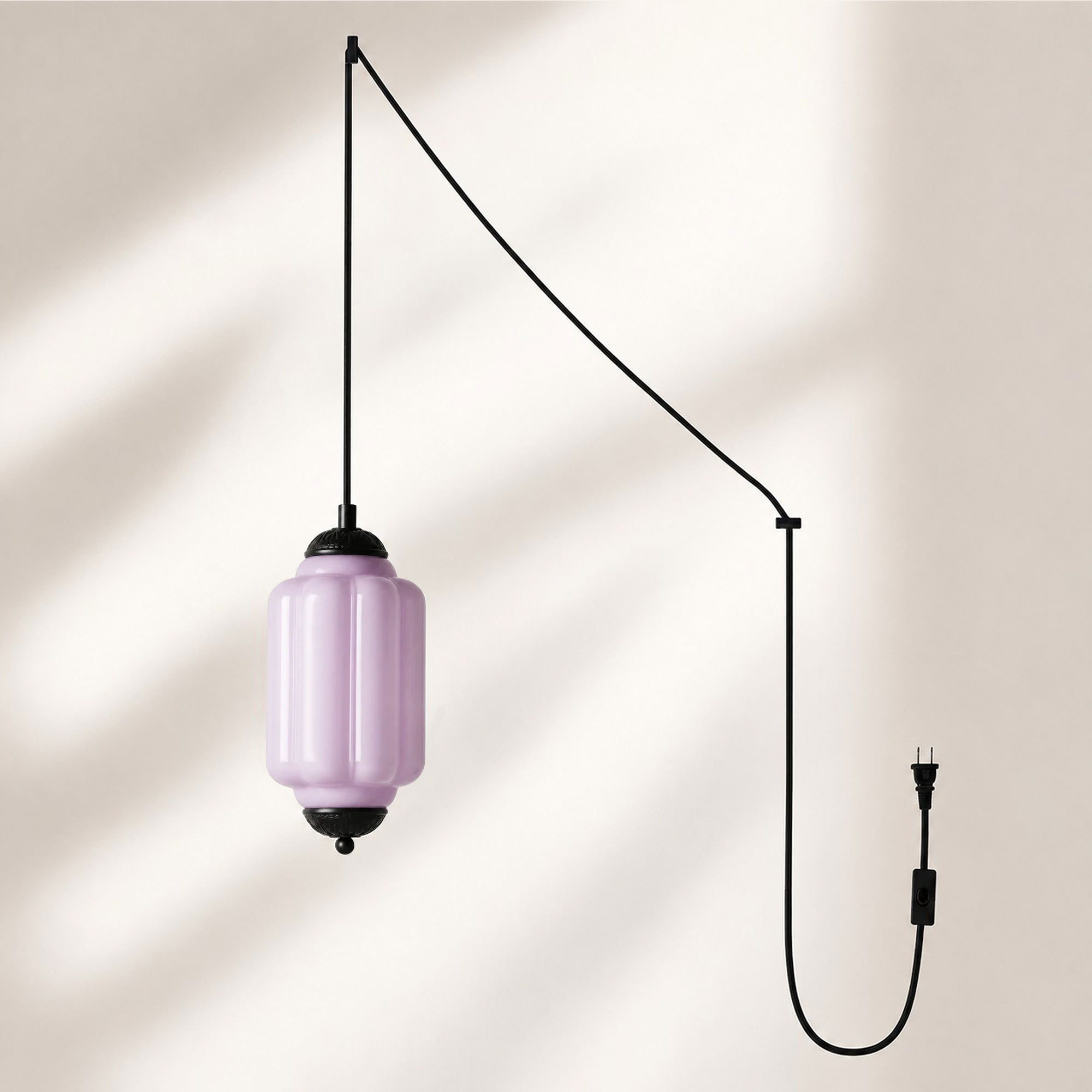 Lámpara colgante con acabado negro y pantalla de cristal color lavanda.