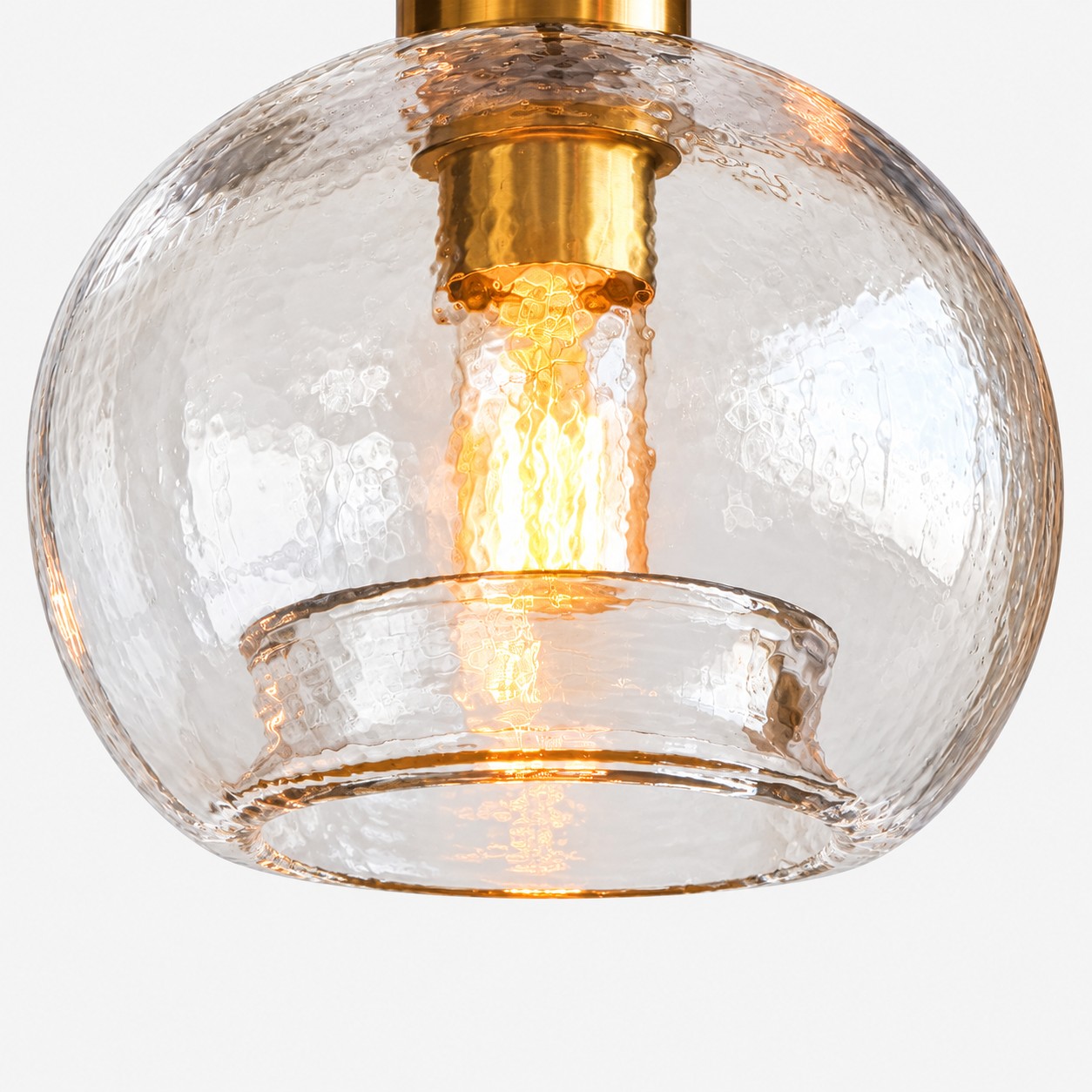 Eine beleuchtete Glühlampe ist durch eine strukturierte Glaskugel mit offenem Sockel sichtbar." loading="lazy