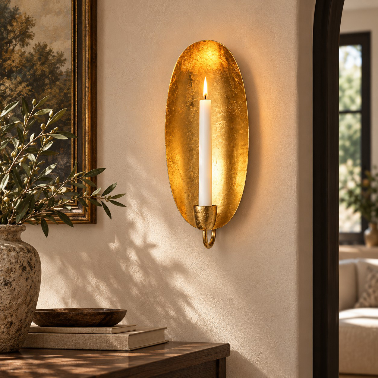 Oval gold leaf wall candle holder beside an archway; illustrative interior