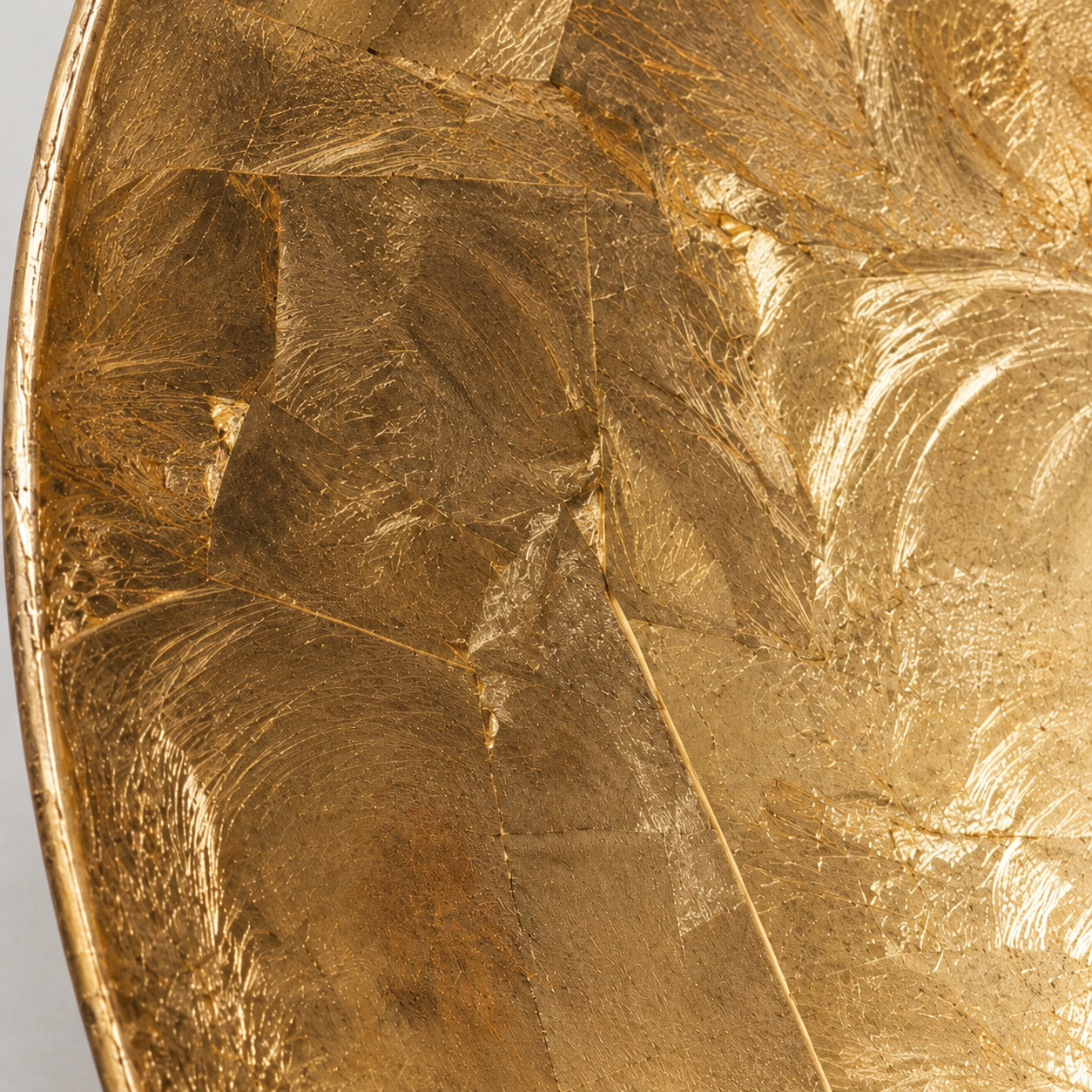 Close-up of the textured gold-leaf surface; original product photograph