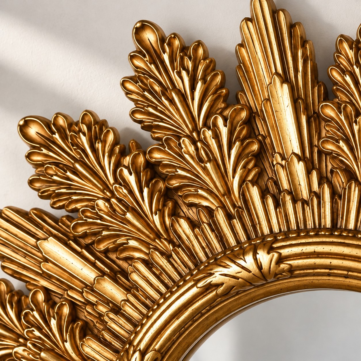 Close-up of layered antique-gold leaf and sunburst mirror frame