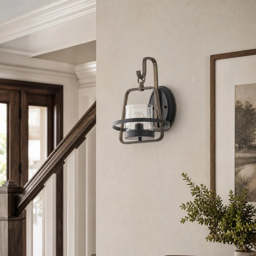 Aplique de pared de metal oxidado y cristal transparente instalado cerca de la escalera y los muebles de entrada.