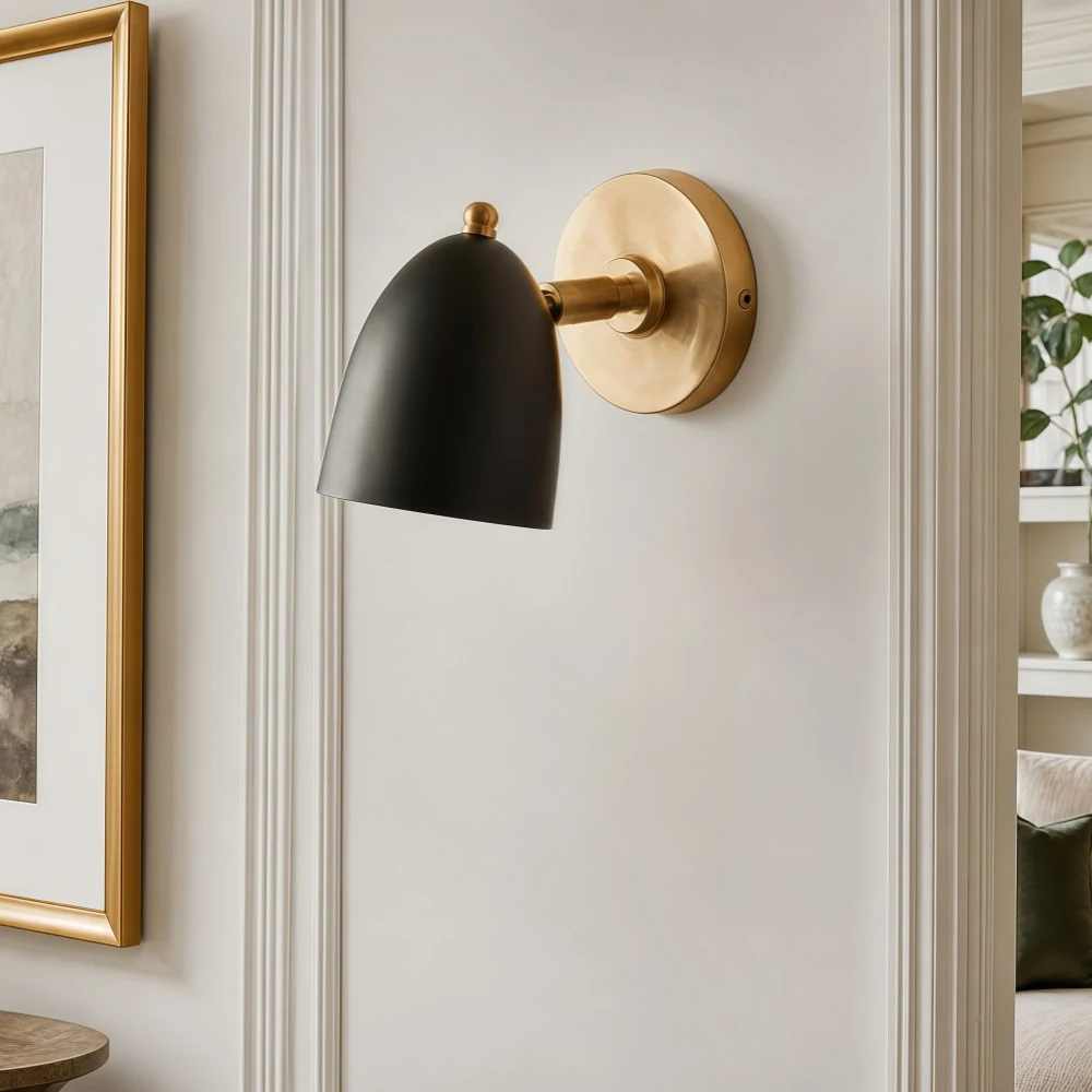 Svart och guldfärgad vägglampa i en elegant väggmiljö