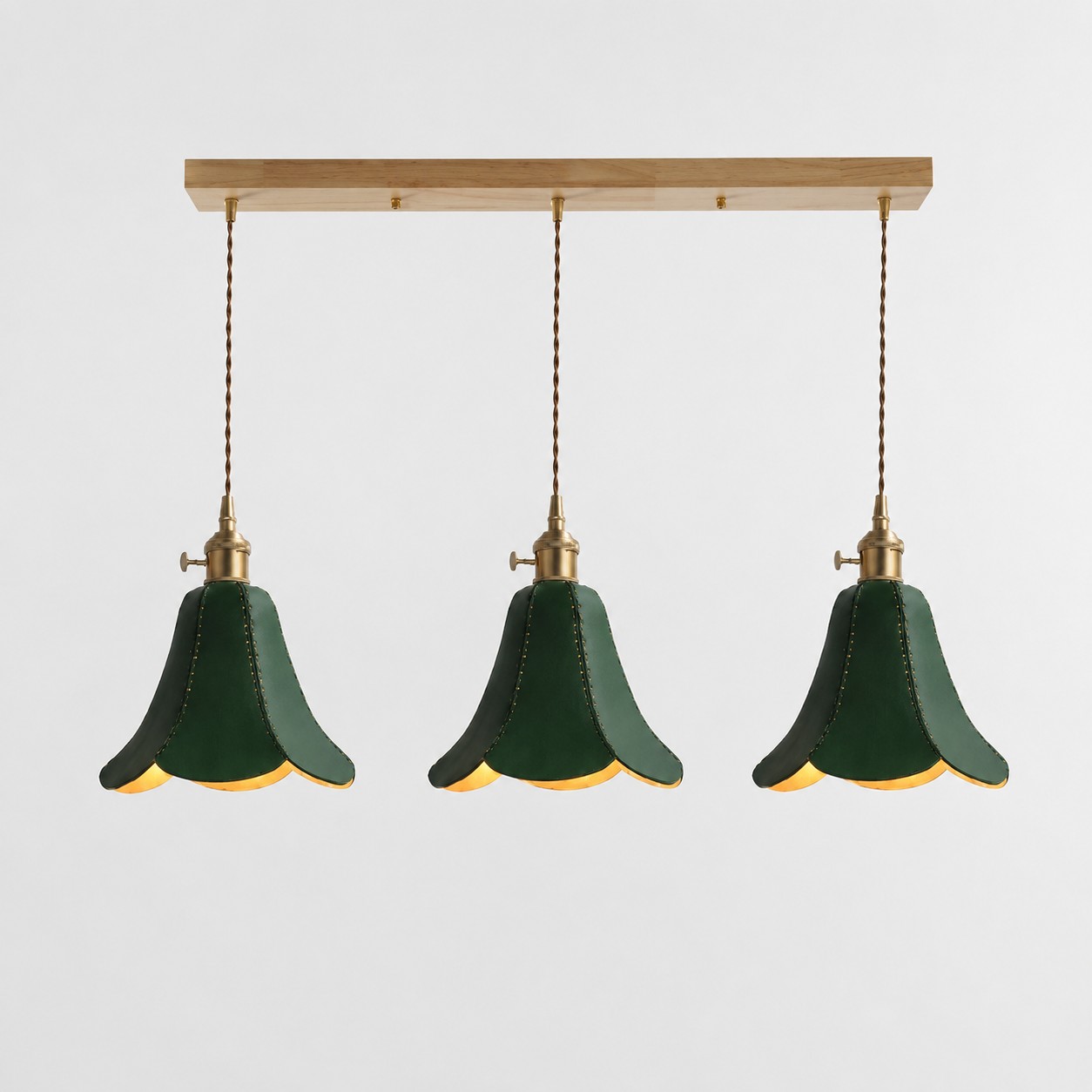 Luminária pendente verde com três pétalas de couro.