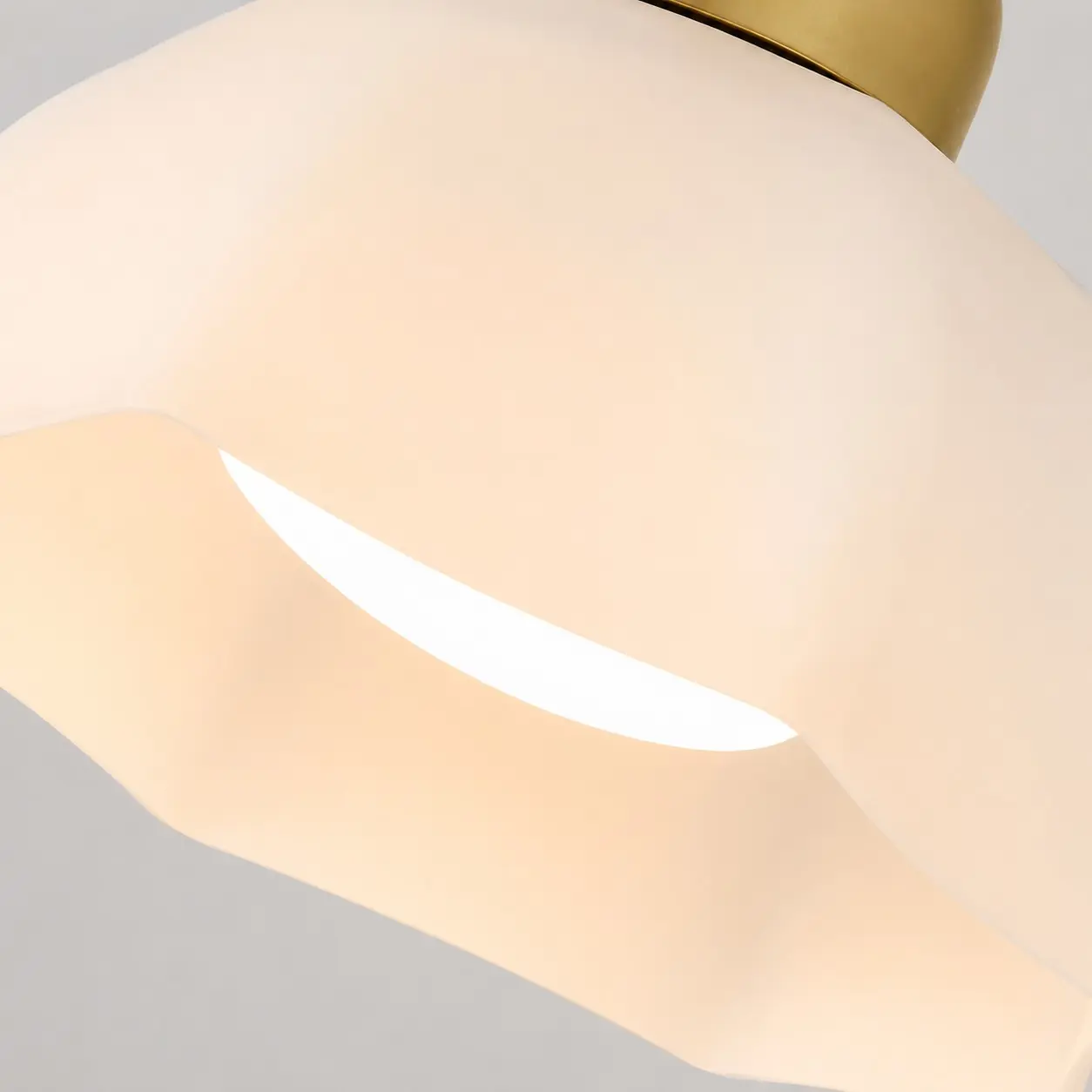 Detailní záběr na tvarované stínidlo z bílého skla