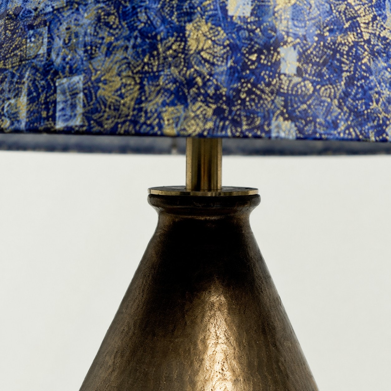Okraj stínidla a detail zlaceného krku lampy