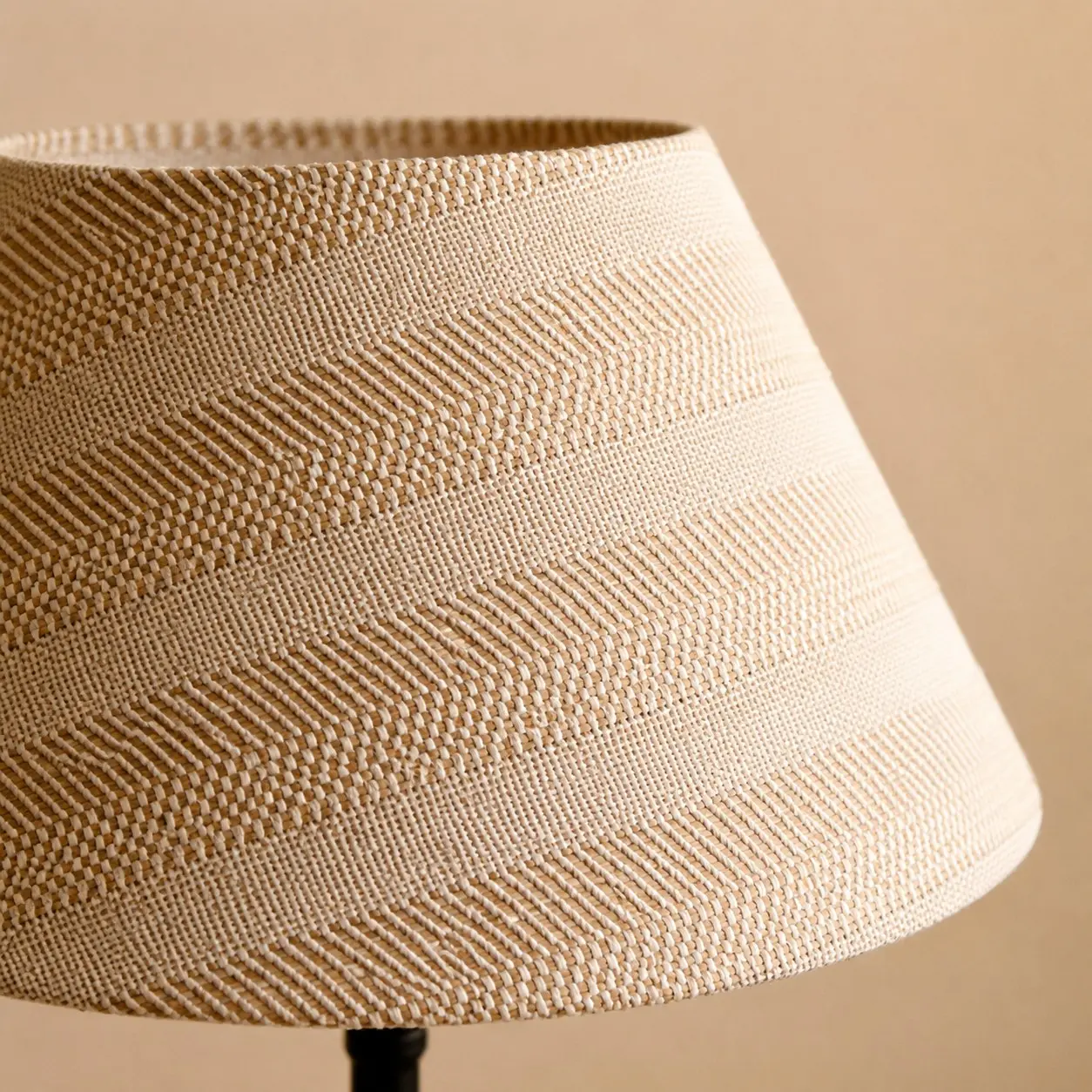 Närbild av den beige rutnätsstrukturen på lampskärmen